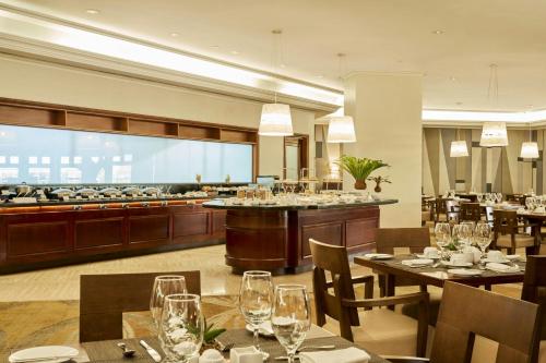 a restaurant with tables and chairs and a buffet at JW Marriott Caracas in Caracas
