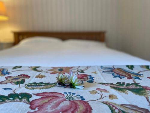 a bed with a floral comforter with a flower pattern at Bryn y Cadno in Hoel-galed