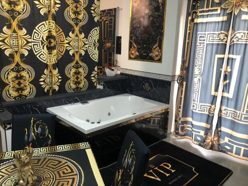 a bath tub in a bathroom with black and gold wallpaper at La Casa Dei Sogni in Lanuvio
