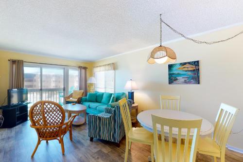 a dining room and living room with a table and a couch at A Place At The Beach 281 in Atlantic Beach