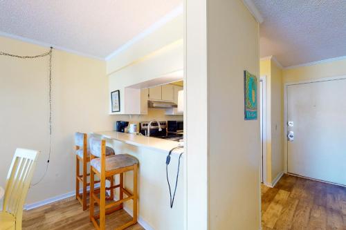 a kitchen with a counter and chairs in a room at A Place At The Beach 281 in Atlantic Beach