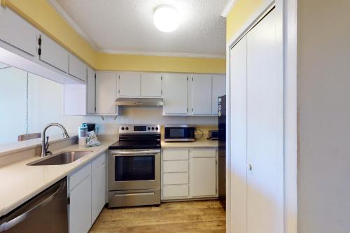 a kitchen with white cabinets and stainless steel appliances at A Place At The Beach 281 in Atlantic Beach