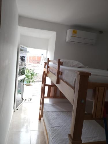sypialnia z dwoma łóżkami piętrowymi i balkonem w obiekcie hostal amanecer costero w mieście Santa Marta