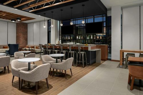 a restaurant with tables and chairs and a bar at Residence Inn by Marriott Lincoln Downtown in Lincoln