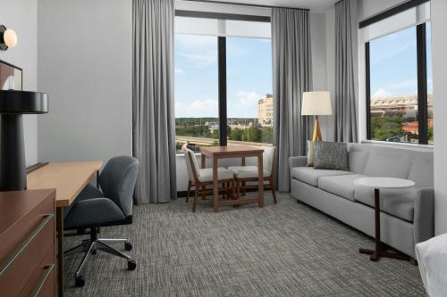 a hotel room with a couch and a desk and a table at Residence Inn by Marriott Lincoln Downtown in Lincoln