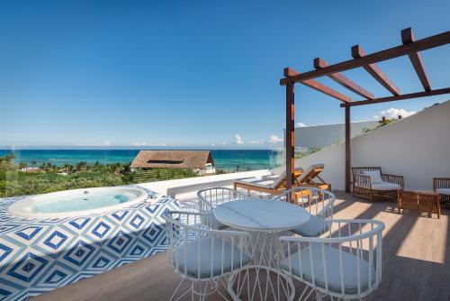 a patio with tables and chairs and the ocean at El Beso Adults Only at Ocean Riviera Paradise All Inclusive in Playa del Carmen