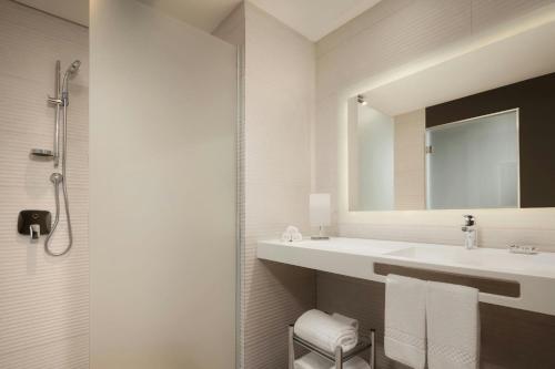 a bathroom with a sink and a mirror at AC Hotel by Marriott Santiago de los Caballeros in Santiago de los Caballeros