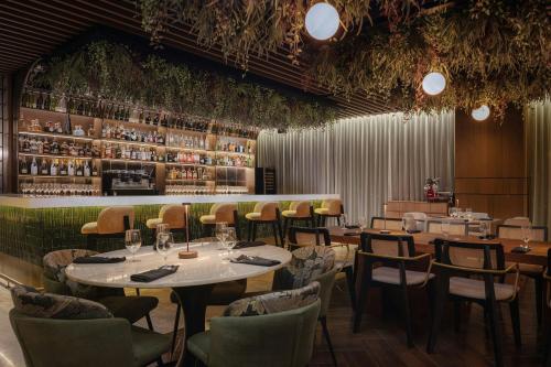 a restaurant with tables and chairs and a bar at AC Hotel by Marriott Santiago de los Caballeros in Santiago de los Caballeros
