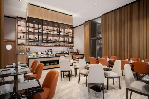 a restaurant with tables and chairs and a counter at AC Hotel by Marriott Santiago de los Caballeros in Santiago de los Caballeros
