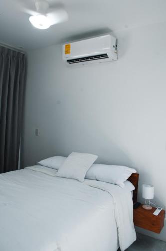 a bedroom with a white bed with a heater on the wall at Blue Banana Villas in San José Pinilla