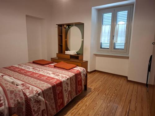 a bedroom with a bed and a large mirror at Appartamento Batticuore in Torre Pellice