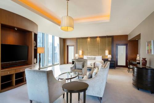 a living room with a couch and a television at JW Marriott Marquis City Center Doha in Doha