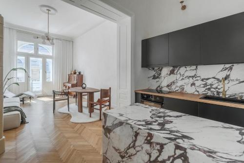a kitchen with a marble counter top and a table at Adorján Apartments - The Grand Salon in Oradea