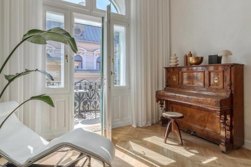 a living room with a piano and a chair at Adorján Apartments - The Grand Salon in Oradea