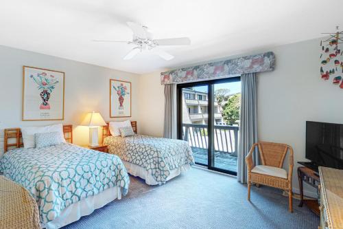a bedroom with two beds and a balcony at PKOG09 Ocean Grove G4 in Pine Knoll Shores
