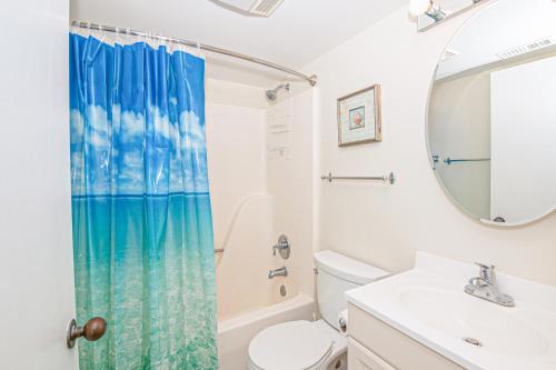 a bathroom with a toilet sink and a shower curtain at PKOG09 Ocean Grove G4 in Pine Knoll Shores