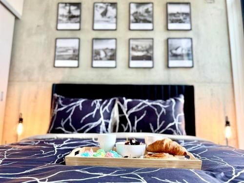 a tray of food and pastries on a bed at Elegant, Comfy & Sophisticated MetroLux Downtown Suite in Calgary