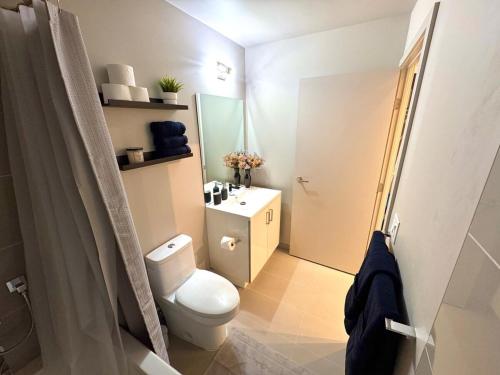 a bathroom with a toilet and a sink and a shower at Elegant, Comfy & Sophisticated MetroLux Downtown Suite in Calgary