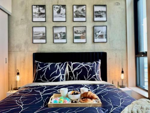 a tray of food sitting on top of a bed at Elegant, Comfy & Sophisticated MetroLux Downtown Suite in Calgary