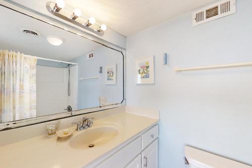 a bathroom with a sink and a mirror at Smugglers Cove 508 in Atlantic Beach