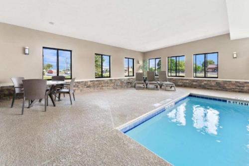 an empty clubhouse with a pool and a table and chairs at Comfort Suites near Robins Air Force Base in Warner Robins
