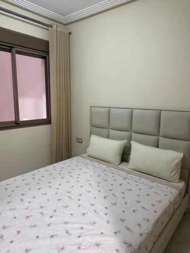 a bedroom with a large bed with a large headboard at trqnche 5 imm k rsd no 189 riad essalam in Tangier