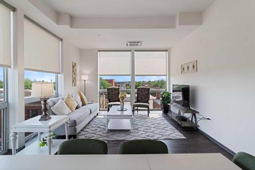 a living room with a couch and a tv at 2BR City Loft Sweeping Glass Views in Chicago