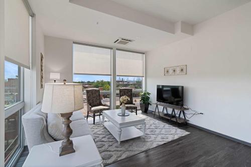 a living room with a couch and a television at 2BR City Loft Sweeping Glass Views in Chicago