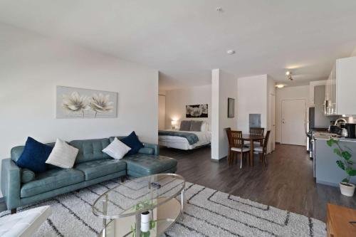 a living room with a green couch and a kitchen at New Modern 1BR Lux City Escape in Chicago
