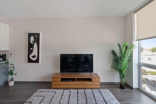 a living room with a tv and a wooden entertainment center at New Modern 1BR Lux City Escape in Chicago