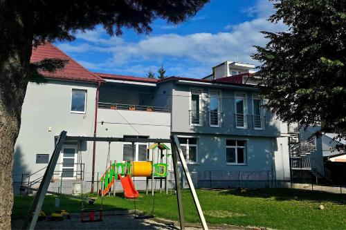 a playground in a yard next to a house at Salón MISSEN in Trenčianske Teplice
