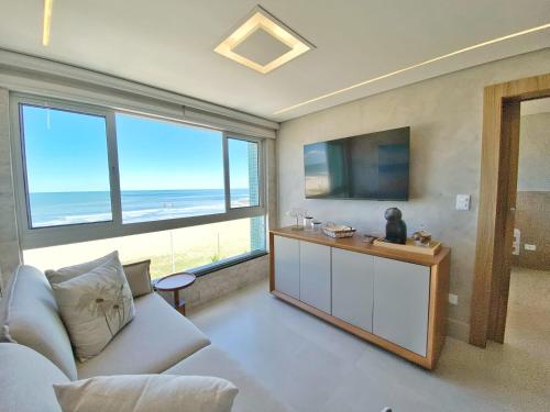 マチーニョスにあるCobertura duplex de frente para o marのソファと薄型テレビのあるリビングルーム