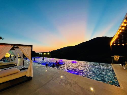 a pool with purple lights in the water at sunset at Estadero Bello Horizonte in Florencia