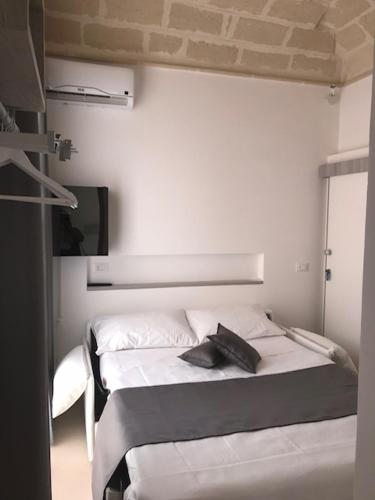 a bedroom with two beds and a tv on the wall at Imera B&B in Favignana