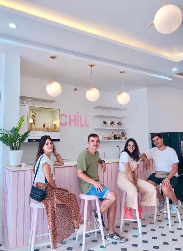 a group of people sitting on stools in a restaurant at The Chill in Hue