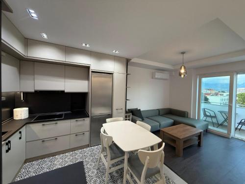 a kitchen and living room with a table and a couch at Shkodra Stylish Apartment in Shkodër