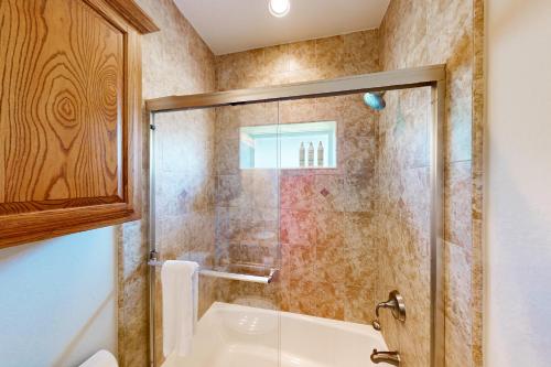 a bathroom with a shower and a white tub at Sea Glass Condominiums 2 in South Padre Island