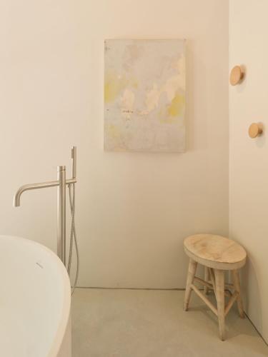 a stool in a bathroom with a painting on the wall at The Church Hall in Ipswich