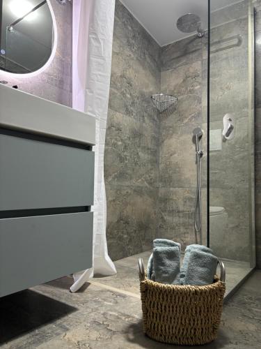 a bathroom with a shower and a basket with towels at Hotel Edelweiss in Ureki