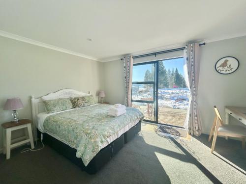 a bedroom with a bed and a window and a desk at Te Manawa Lakeside Garden in Lake Tekapo