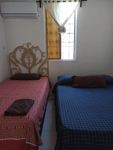 a bedroom with two beds and a window at Hospedaje a 10 min de aeropuerto Internacional de Monterrey in Monterrey