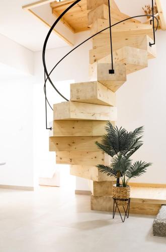 a wooden staircase in a living room with a potted plant at Casas do Freixial - Casa do Beco in Fundão