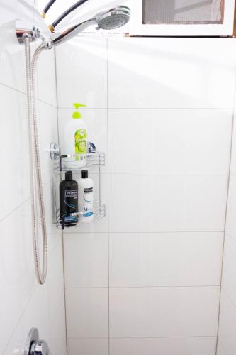 a shower in a bathroom with white tiles at MP Beach Club in Tootgarook