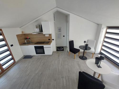 a room with a kitchen with two tables and chairs at Oasi Relax in Borgo Isonzo