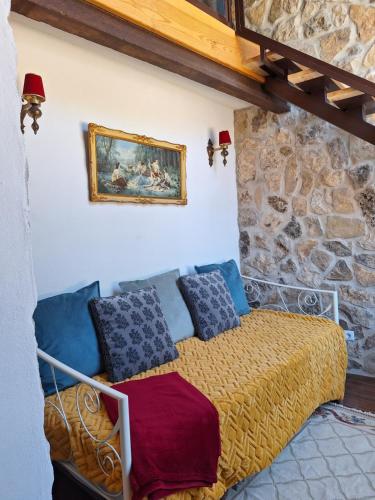 a bedroom with a bed in a stone wall at Casal rural de charme agradável e acolhedor in Arrimal