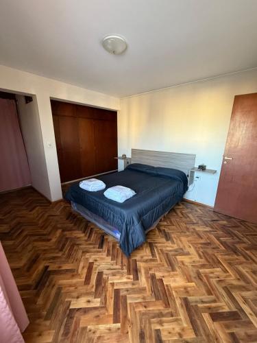 a bedroom with a bed and a wooden floor at Departamento NILO in San Rafael