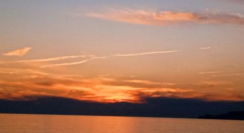 a sunset over a body of water at Sunflower in Tavarone