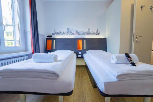 a room with two beds and a window at easyHotel Zürich City Limmatplatz in Zürich