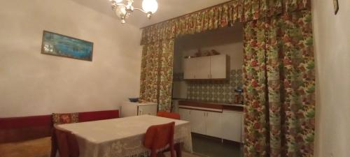 a dining room with a table and a kitchen at Ruza in Gornja Trepča