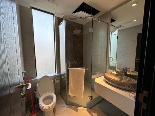 a bathroom with a toilet and a sink and a shower at The Gulberg Apartments in Lahore